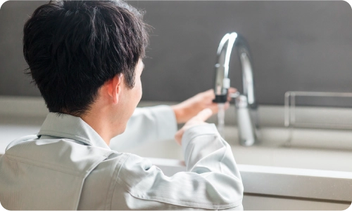 水漏れ修理するスタッフ